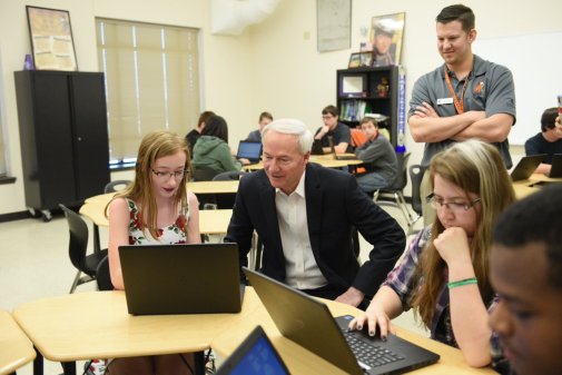 Arkansas Gov. Asa Hutchinson sits with computer science students