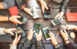 people holding phones at table