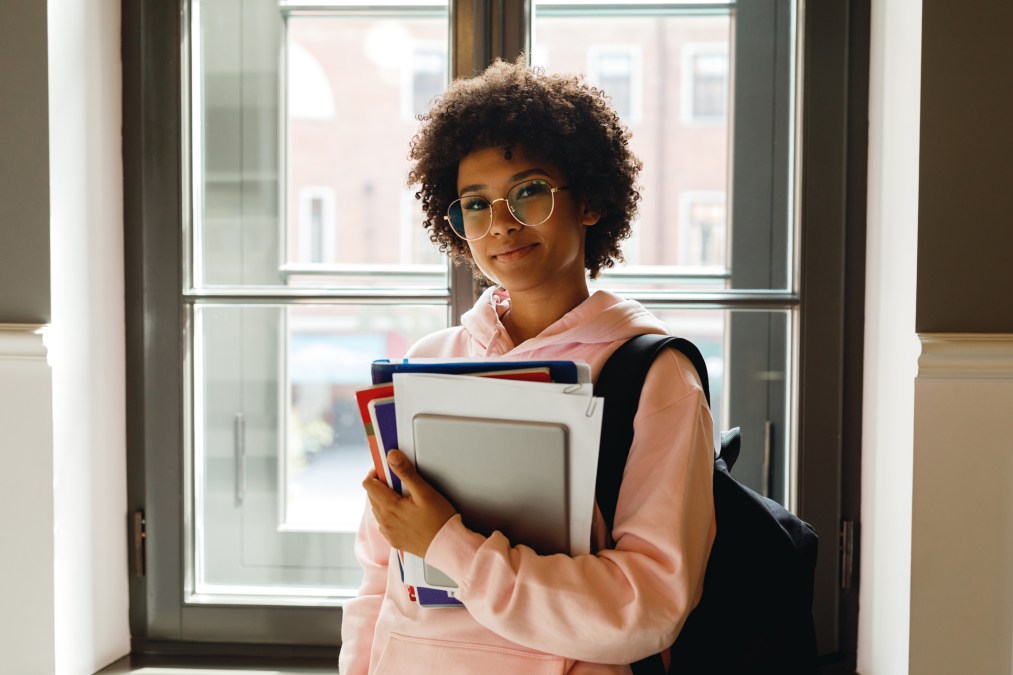 college student standing by a window