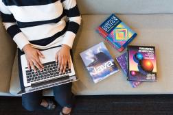 woman with laptop and coding textbooks