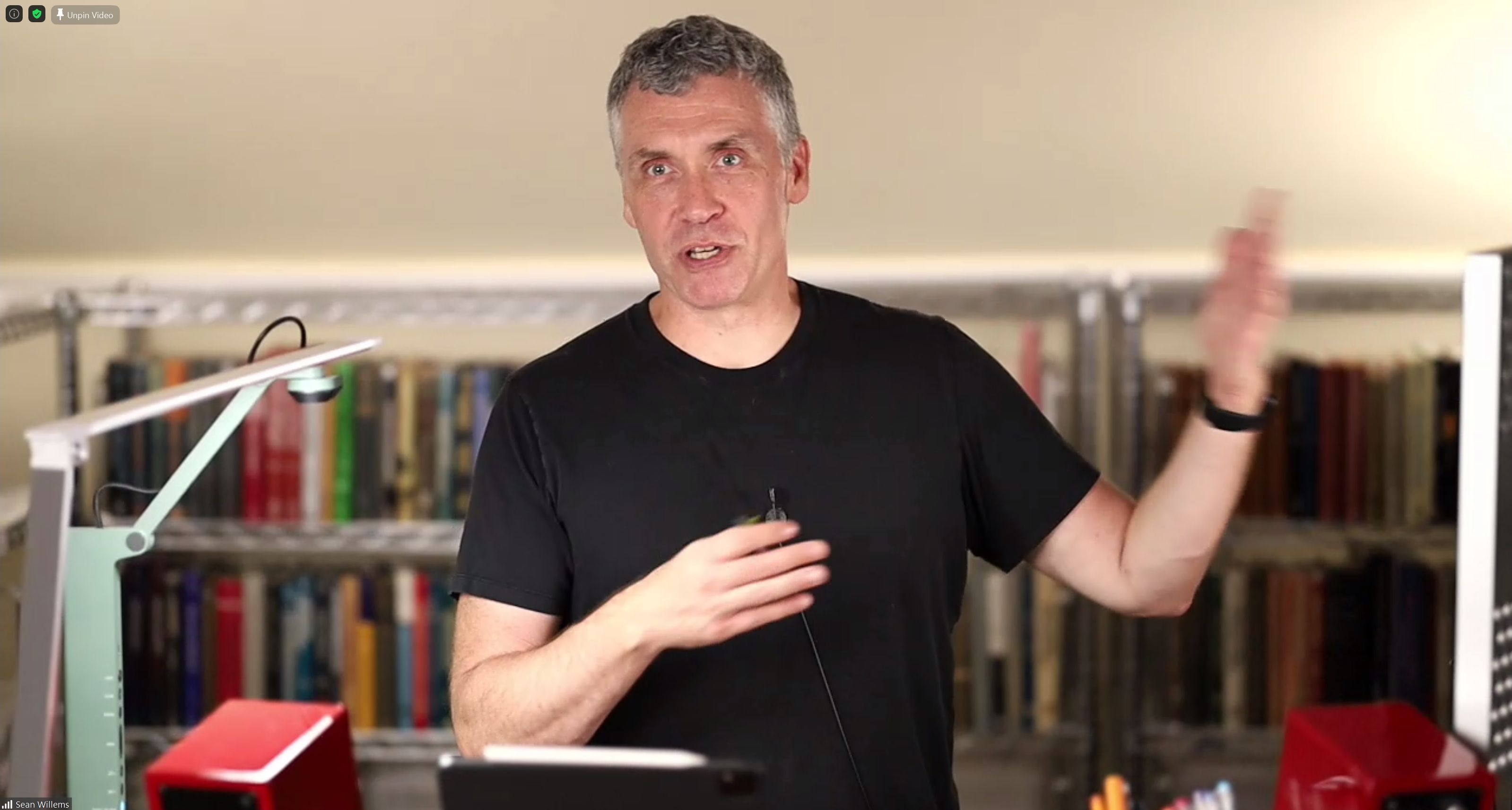 Sean Willems faces the camera in front of a bookcase in his home studio.