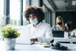 man wearing mask using computer