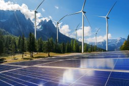 solar panels and wind turbines near mountains