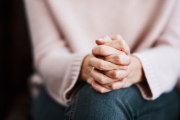 woman with interlocked fingers on knee