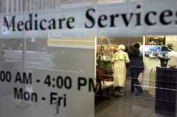 Two people walk inside a Medicare Services office on the last day for enrollment in the Medicare Part D program May 15, 2006 in New York City.